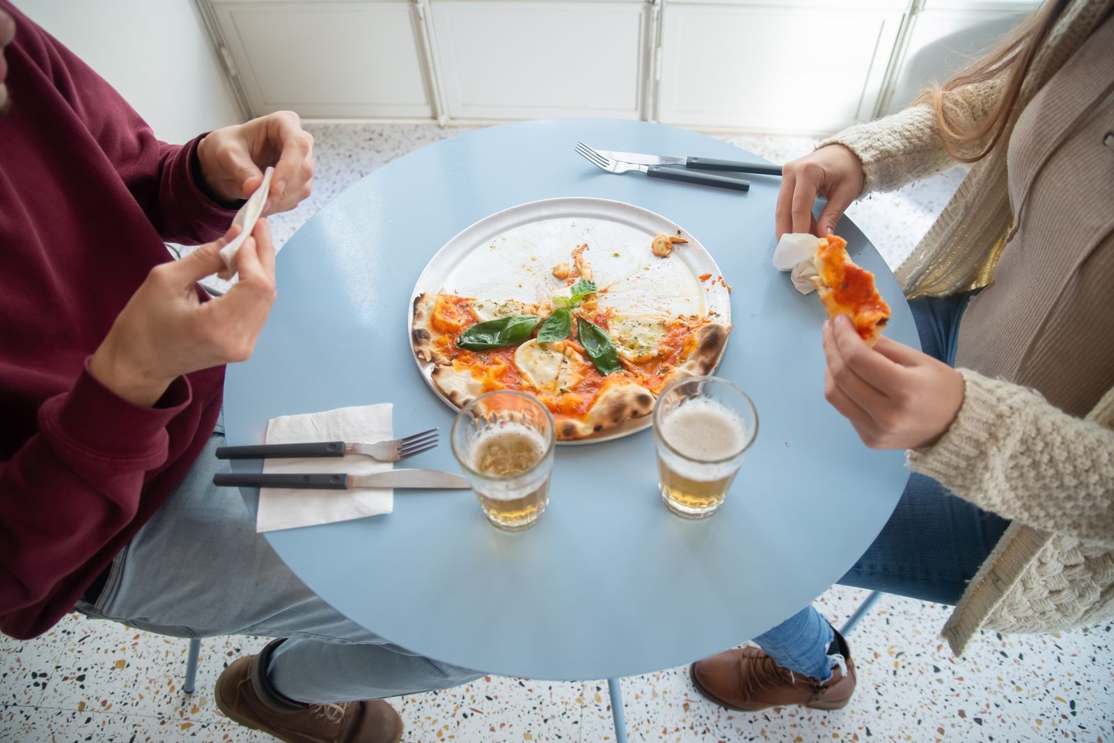 Pessoas reais em mesa de restaurante com pizza